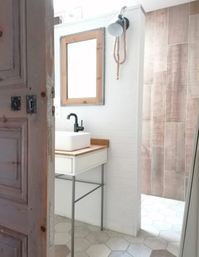 Salle de bain avec miroir blanc style industriel, carrelage sol hexagonal